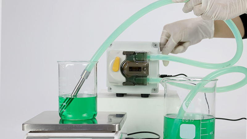 peristaltic pump system transferring liquid through flexible tubing